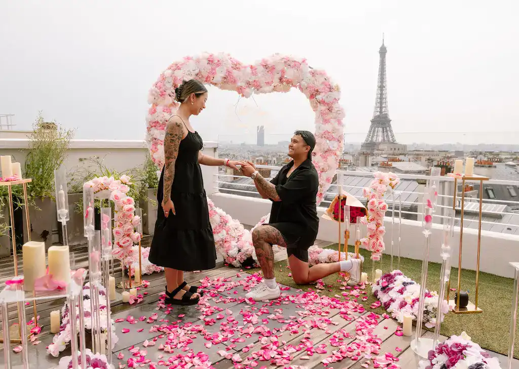 Couple's romantic proposal on rooftop with Eiffel Tower in background.